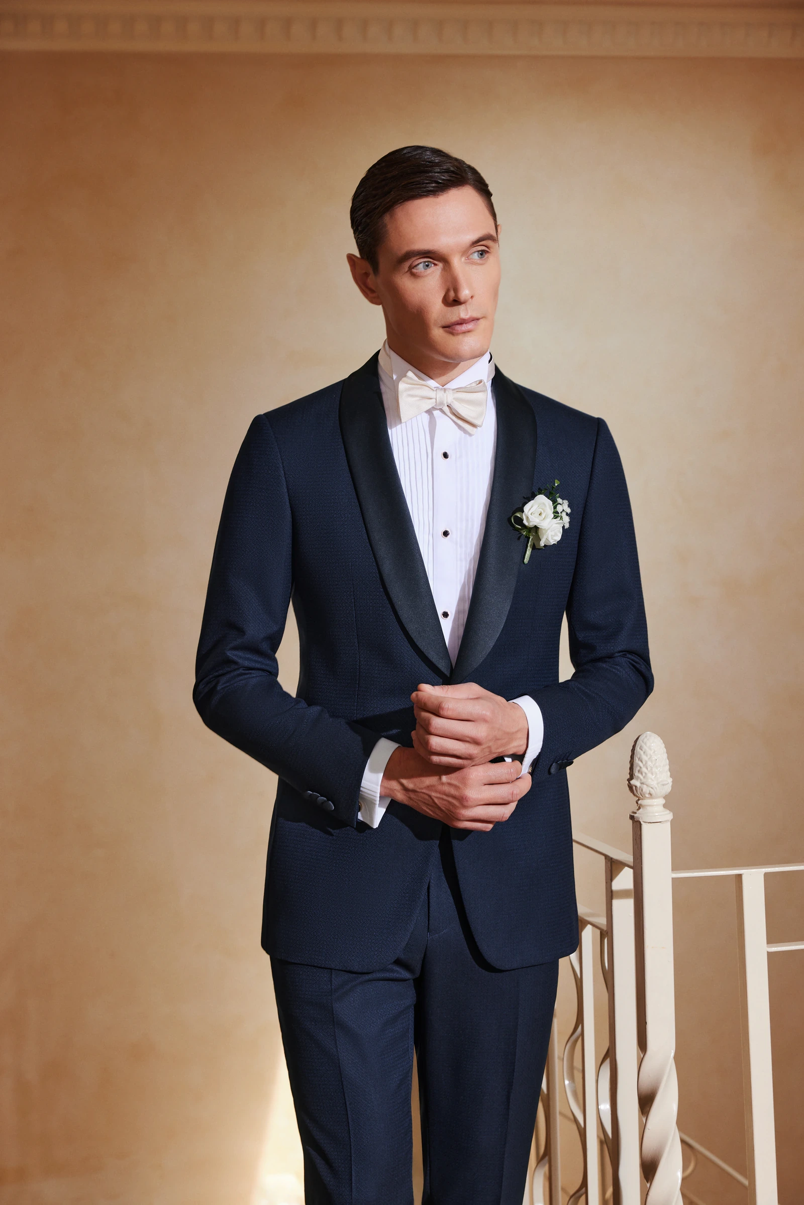 Man wearing a navy wedding suit with a white boutonniere