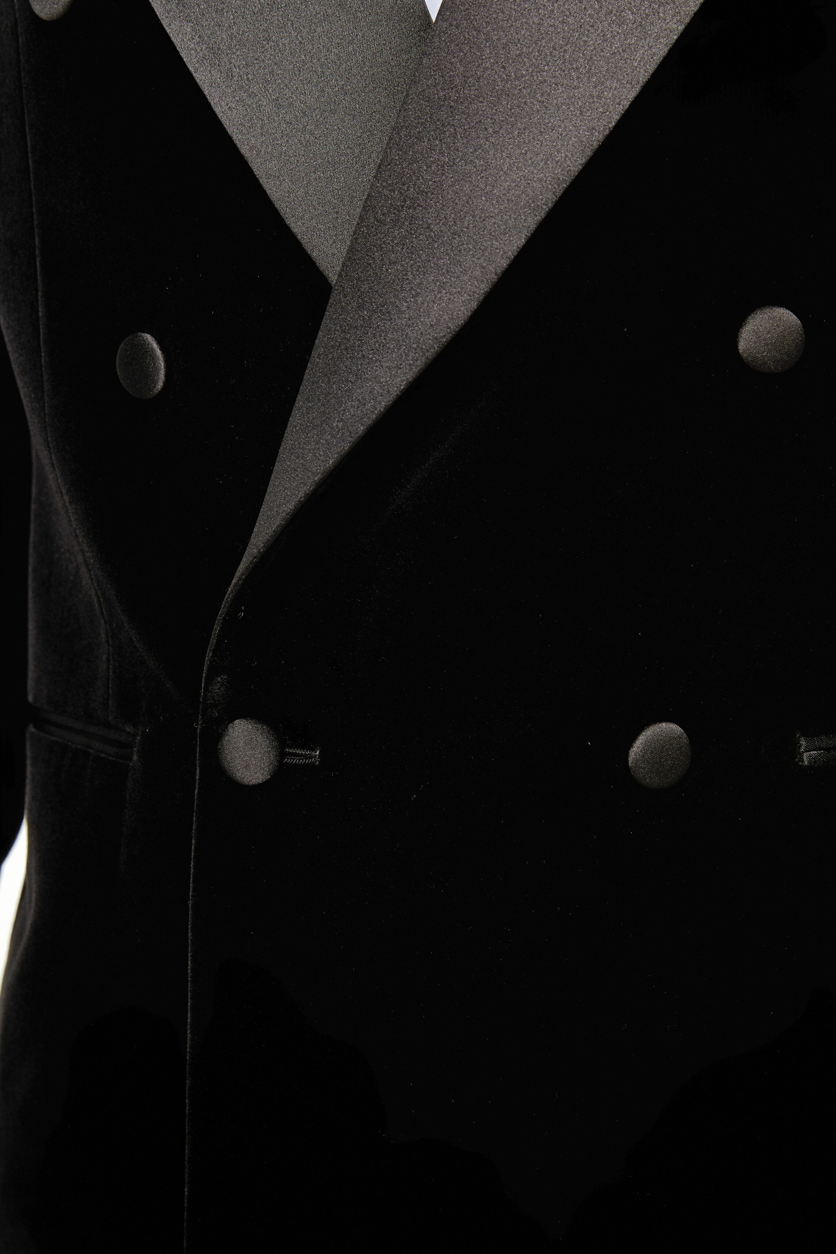 Covered button detail on black velvet dinner jacket.