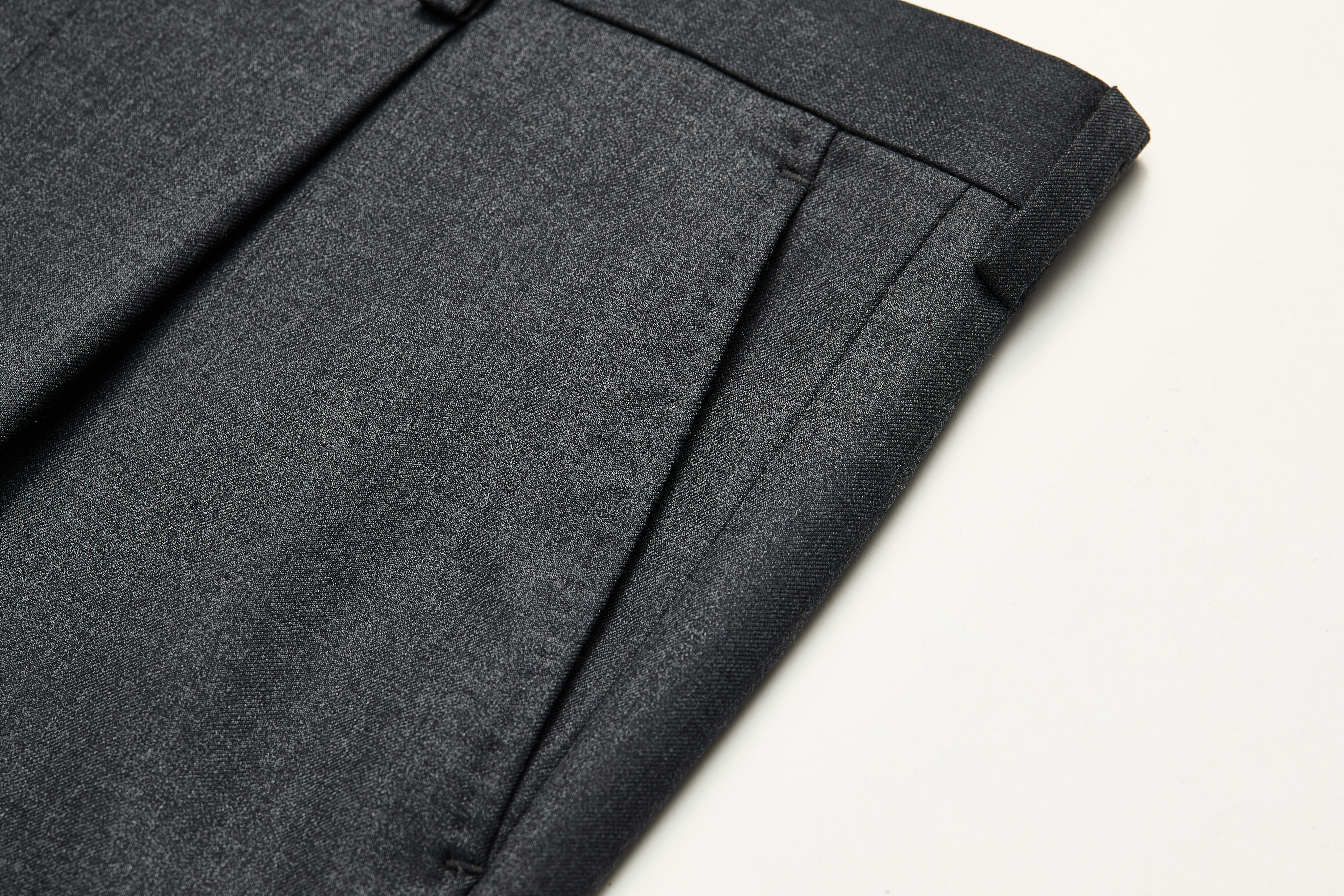 ¼-top pocket detail on charcoal trousers.