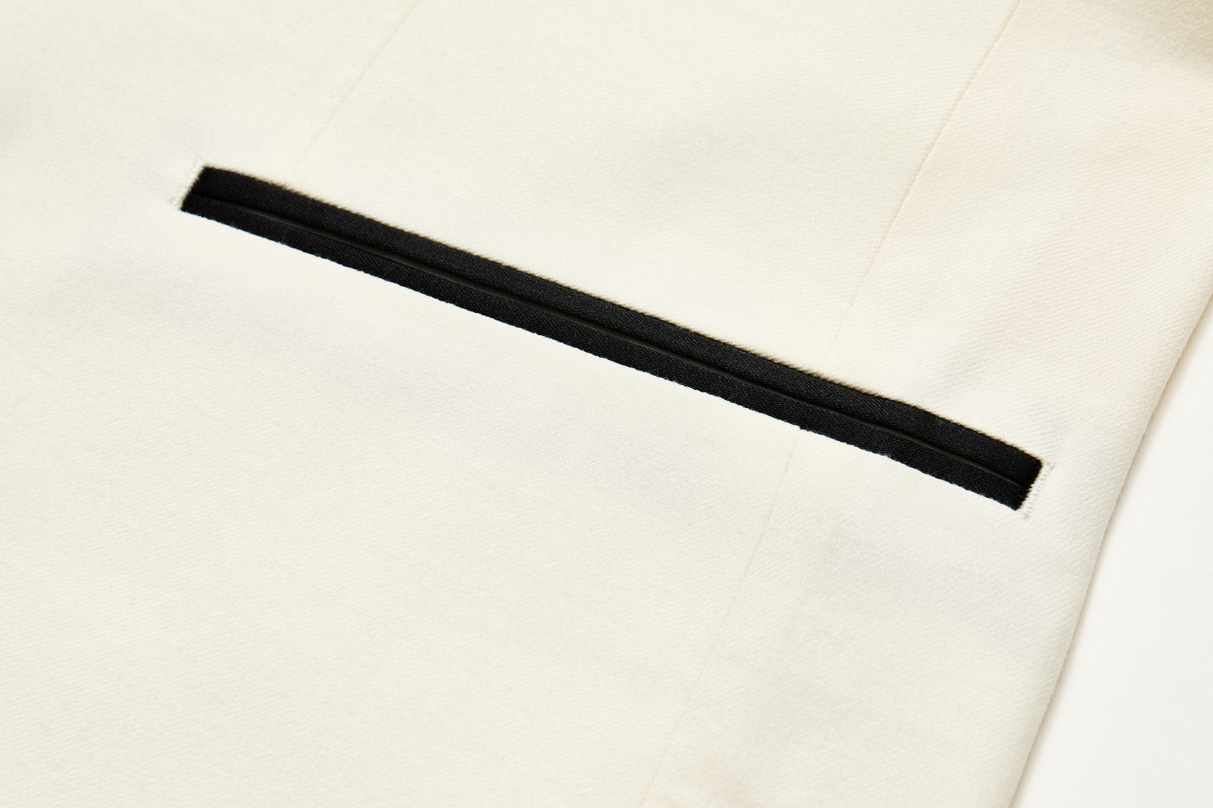 Black silk jetted pocket on ivory dinner jacket.