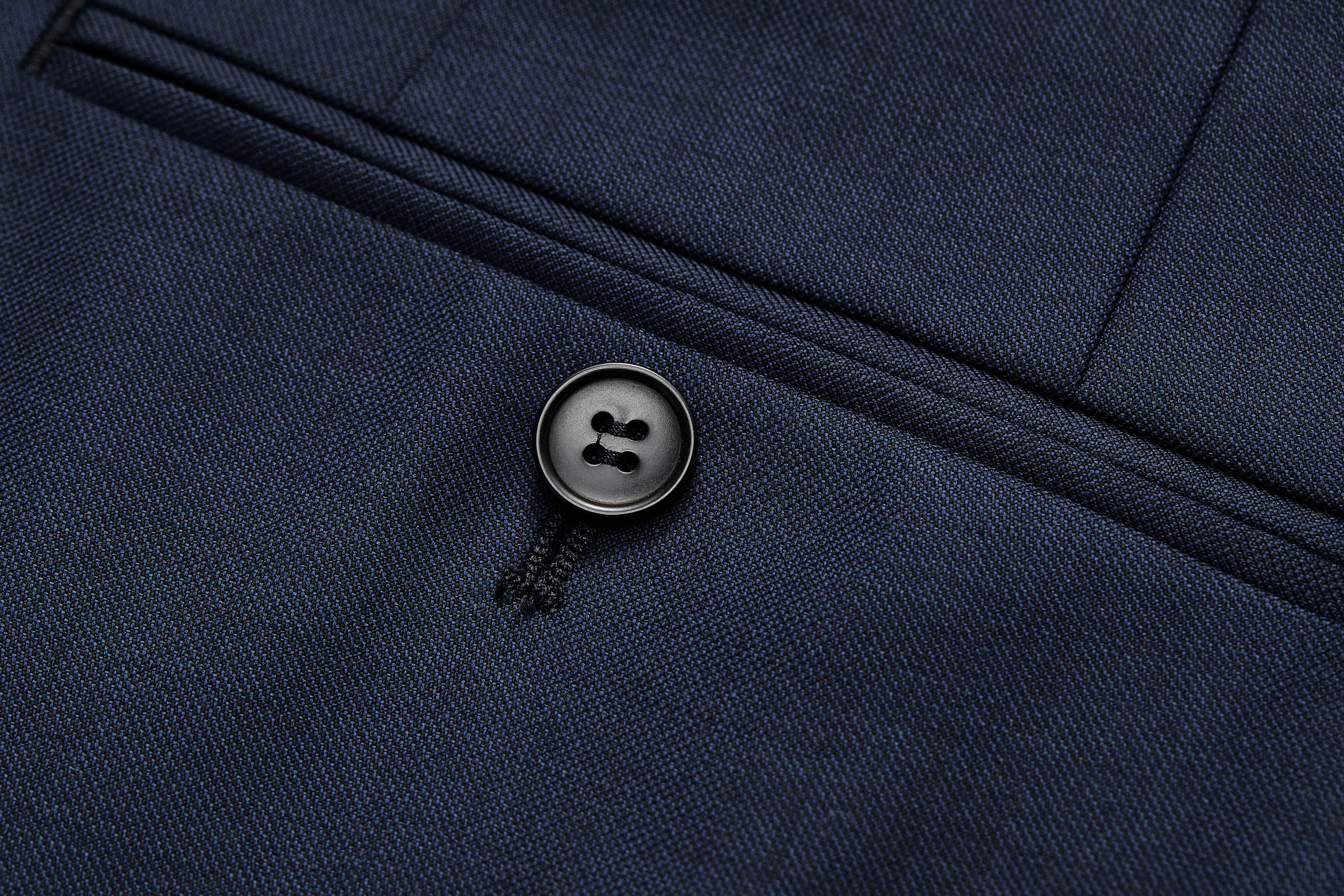 Jetted back pocket detail on navy trousers.